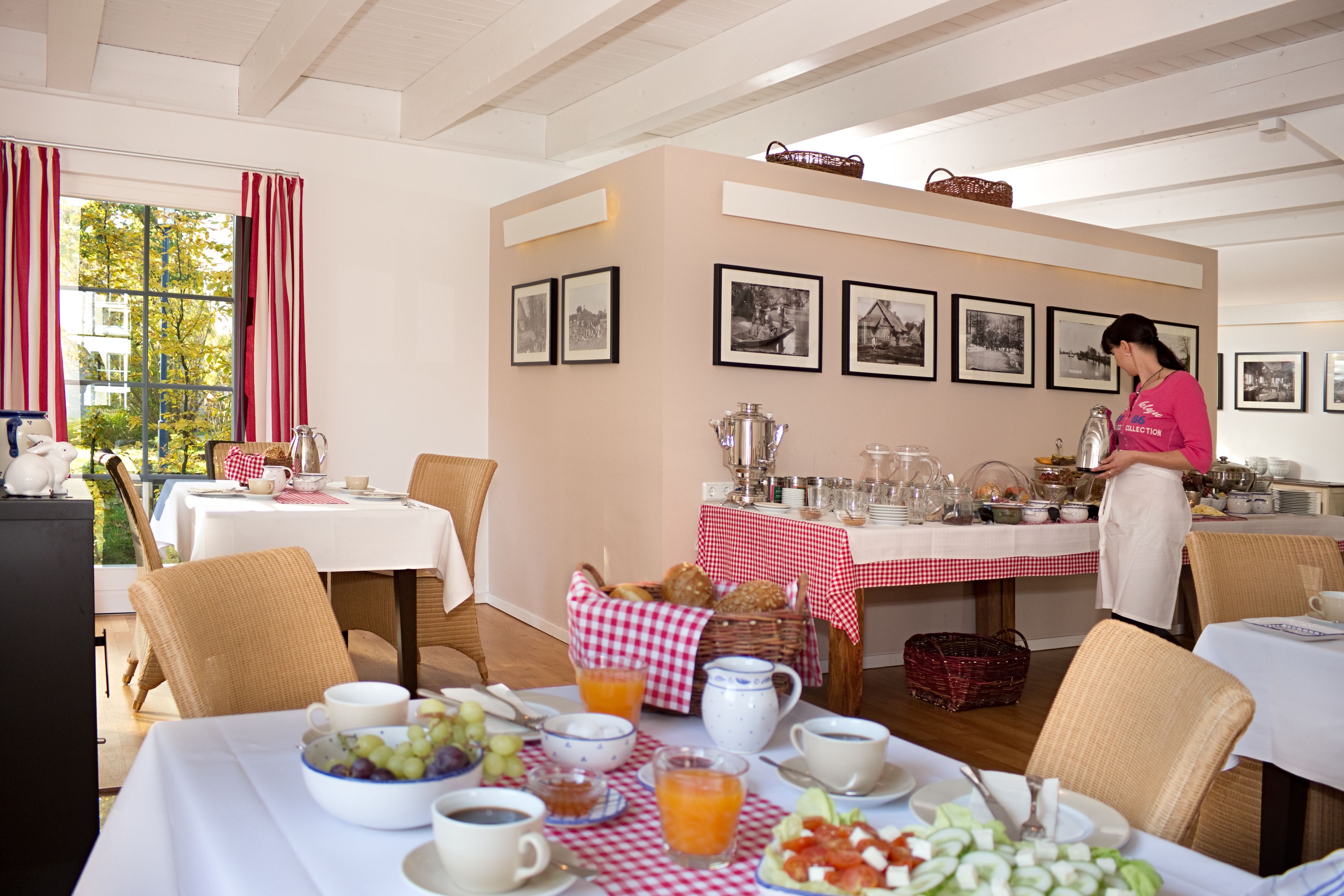 Un espacio para el desayuno con mesas, sillas y una zona de buffet.