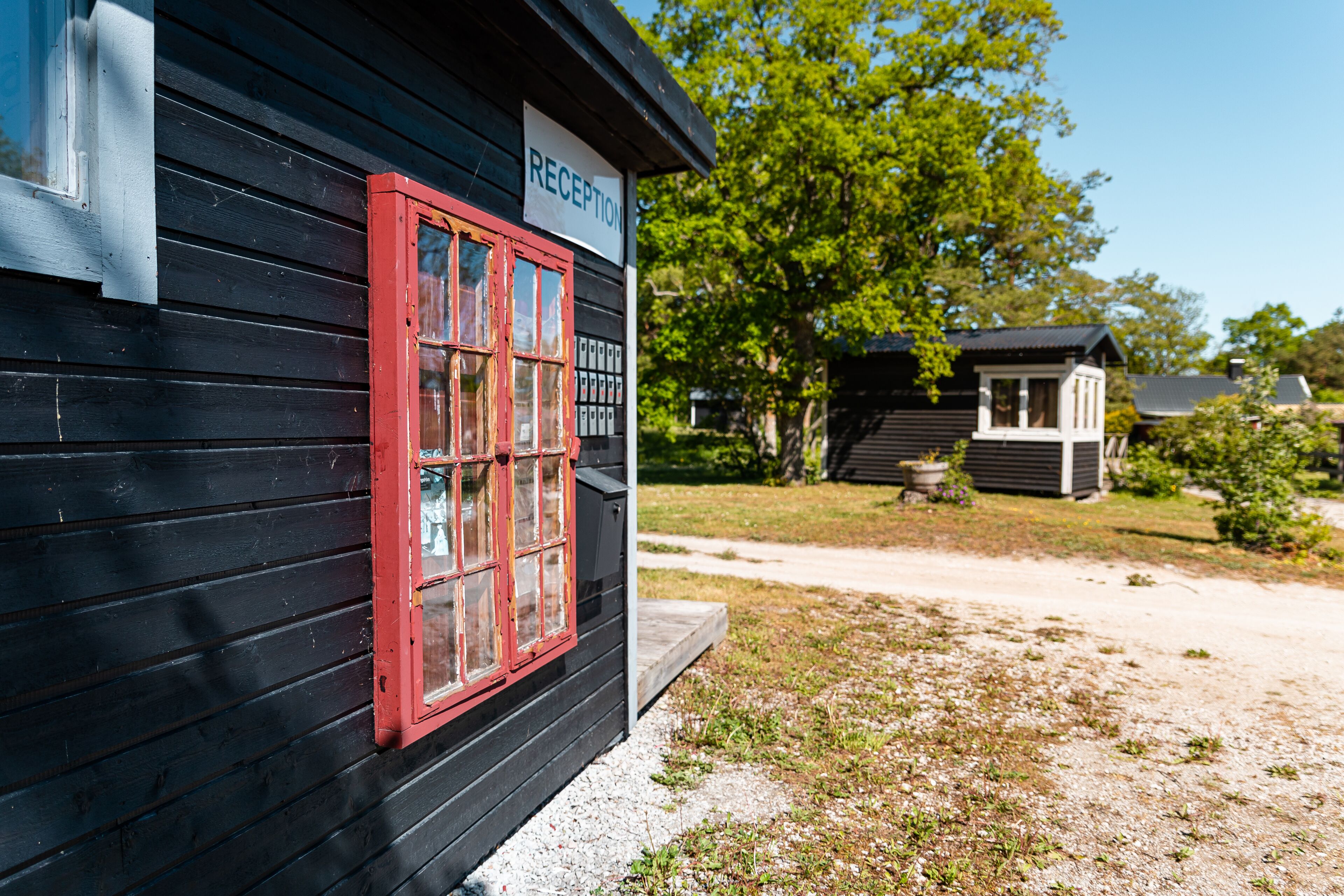 A black building with a red-framed window and a sign that reads "RECEPTION".