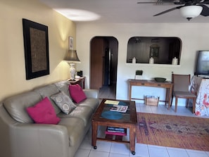 Sala de estar com sofá, mesa de centro e televisão.