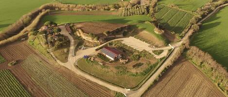 Vista aérea de una propiedad rural con campos, una casa de campo e instalación de paneles solares.