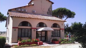 A building with a tiled roof, arched windows, and a sign that reads "Il Padrino." - Agriturismo Il Poderino (Tarquinia)