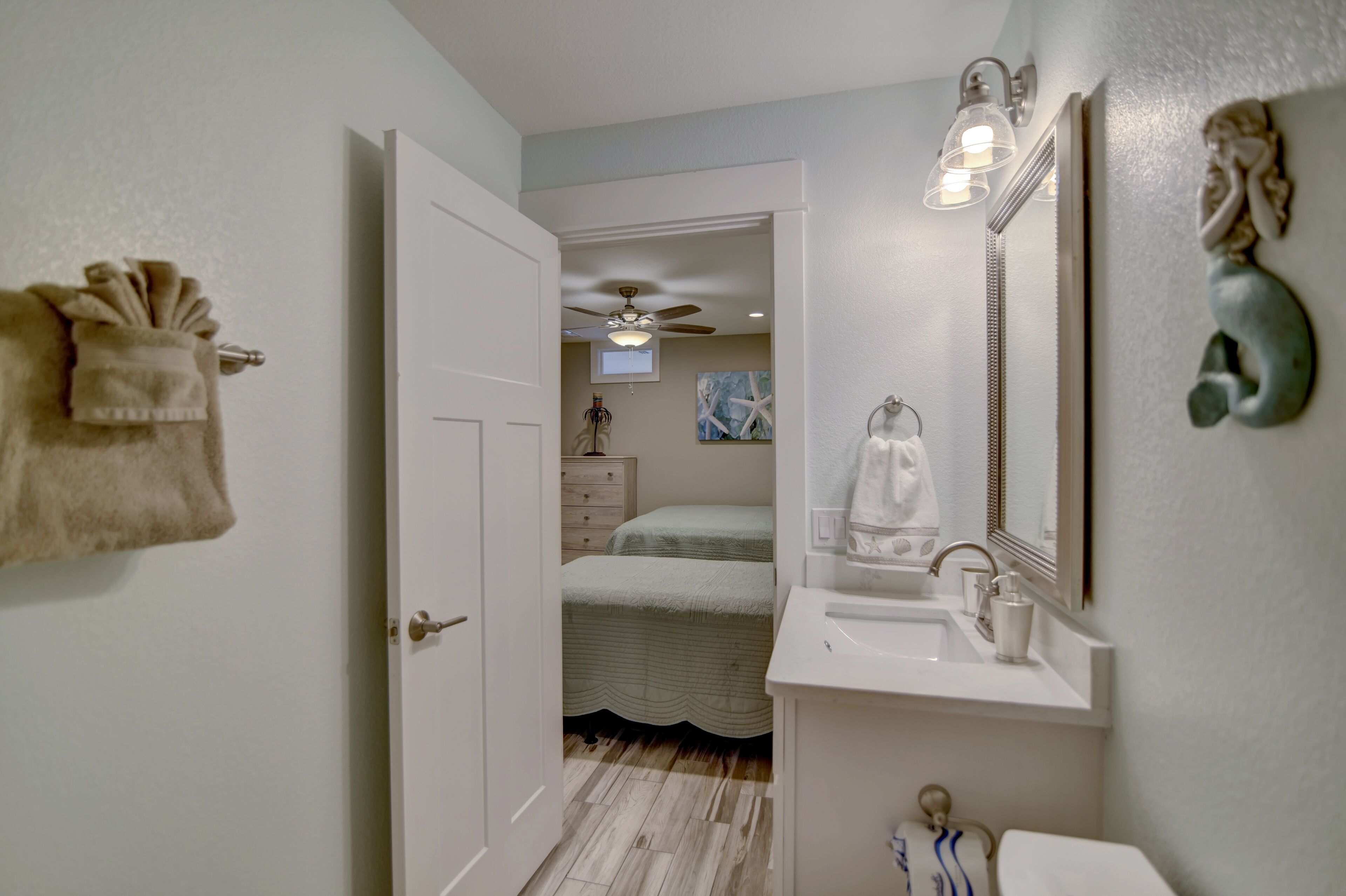 A bathroom with a white sink, a mirror, and a ceiling fan.