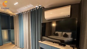 A modern hotel room with a bed, an air conditioning unit, a flat-screen TV, and a control panel. - Comfort Inn Silver Arch Hotel, Mussoorie (Dehradun)