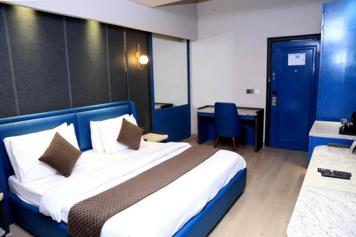 Hotellihuone, jossa on suuri sänky, työpöytä ja tuoli.