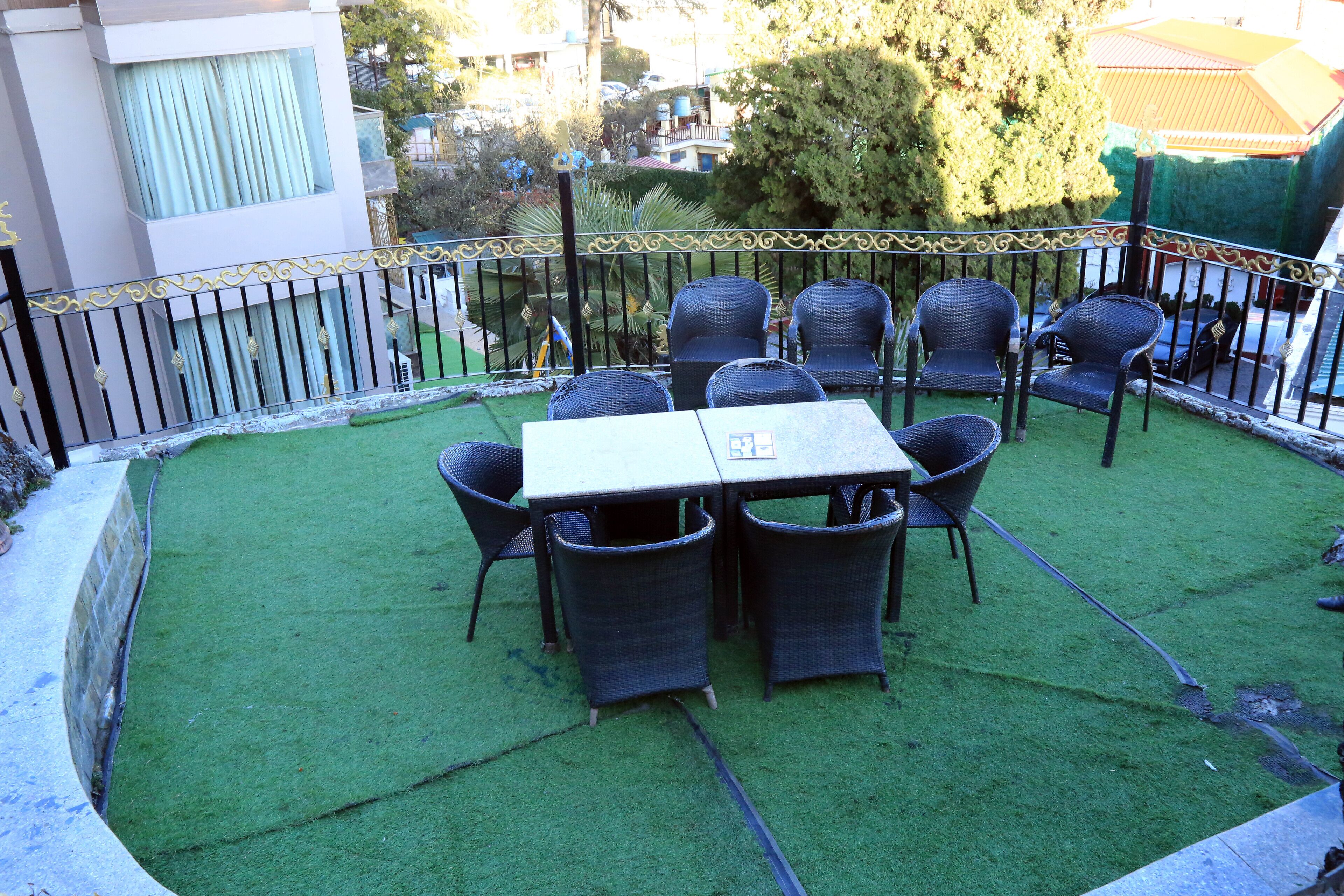 Un patio con mesa y sillas, rodeado por un cerramiento decorativo.