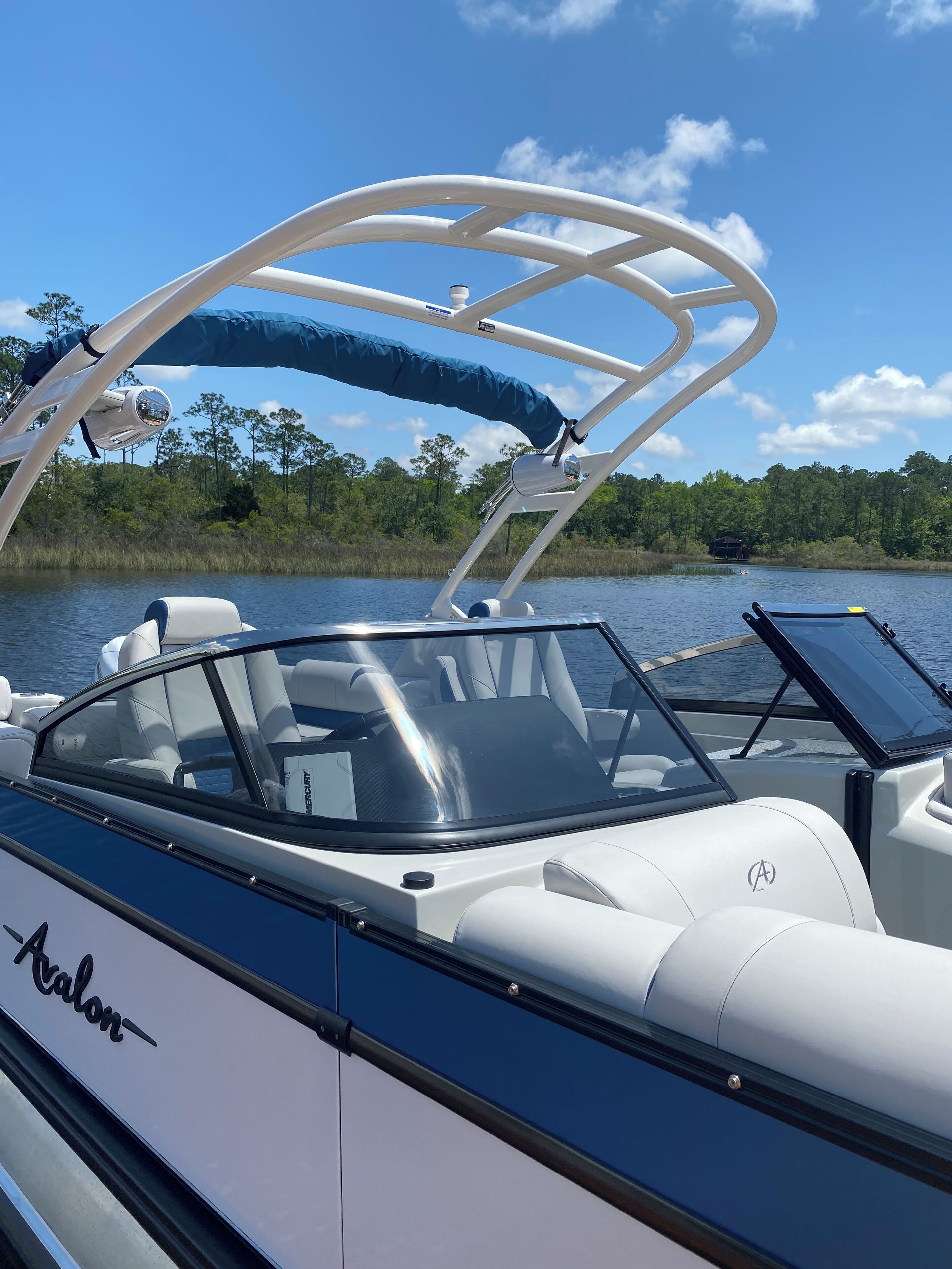 Un bateau doté d’un espace de sièges couvert, d’un volant et d’une marque visible sur le côté.