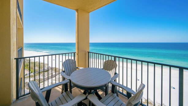 A balcony with a view of the ocean and beach, a round table with chairs, and a railing. - One bedroom…Phoenix V…Gulf Front Condo #1214 (Orange Beach)