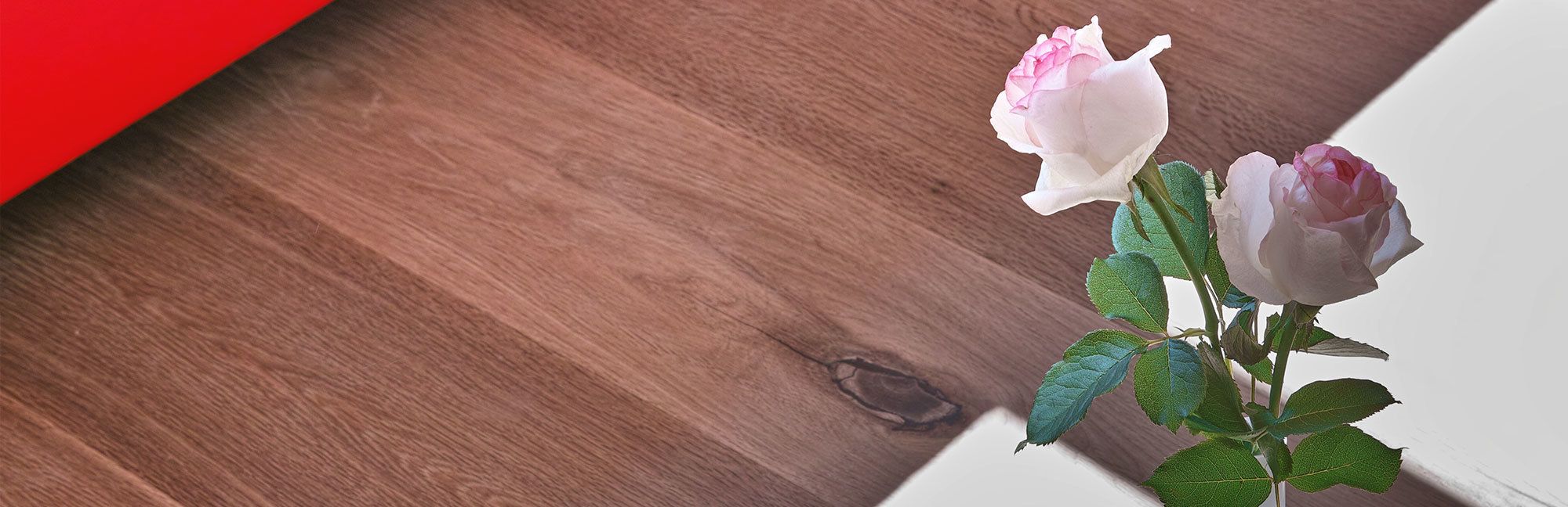 Superfície de madeira com uma rosa e folhas.