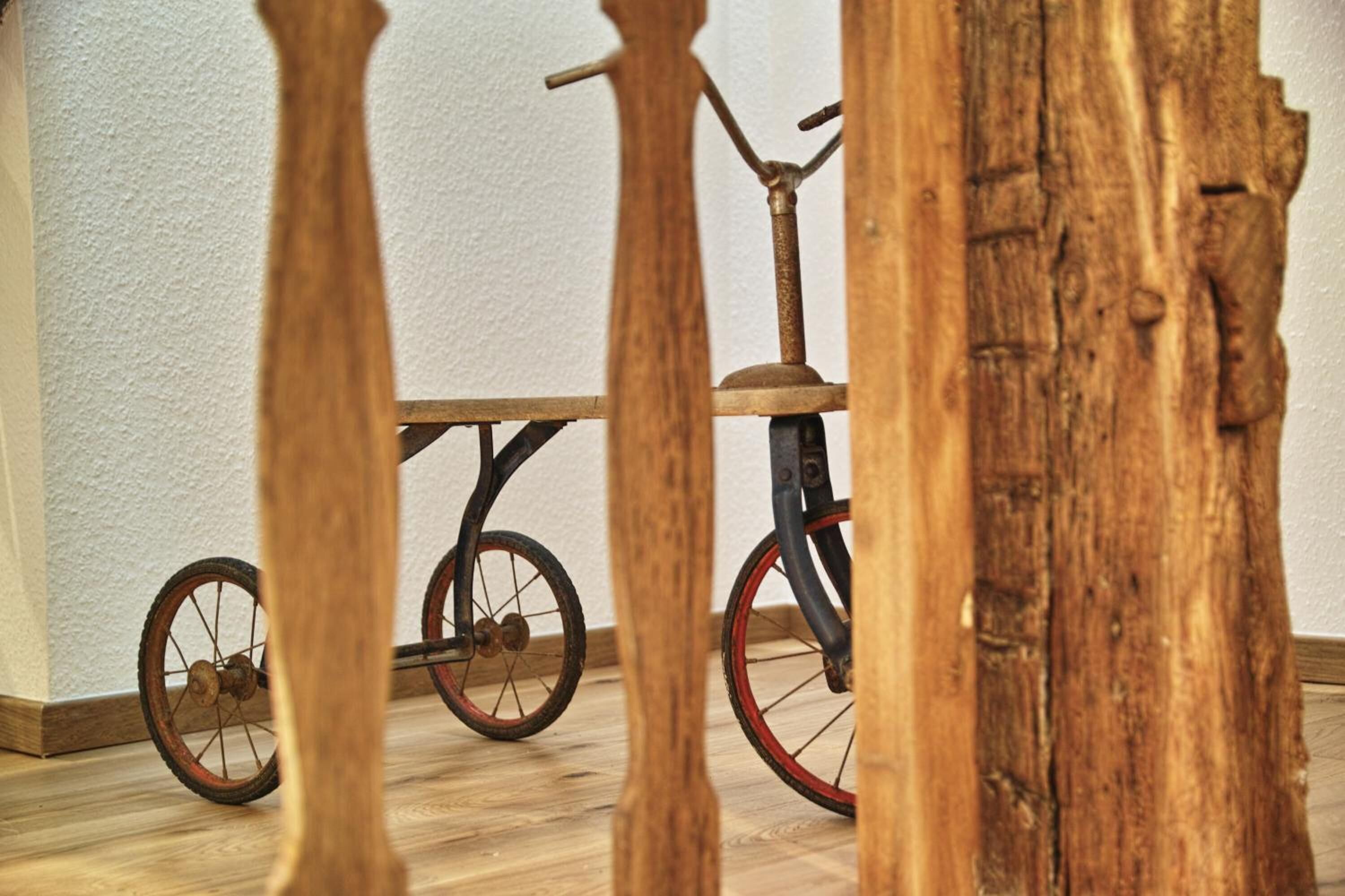 A wooden floor with a bicycle leaning against a wall.