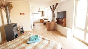 A cozy room with a fireplace, a sofa, a TV, and a dining area. - Elbschloss Kehnert (Tangerhütte)