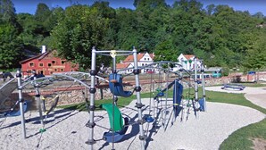 An outdoor playground with climbing structures and a gravel ground. - Mini Hotel Abraka (Cesky Krumlov)