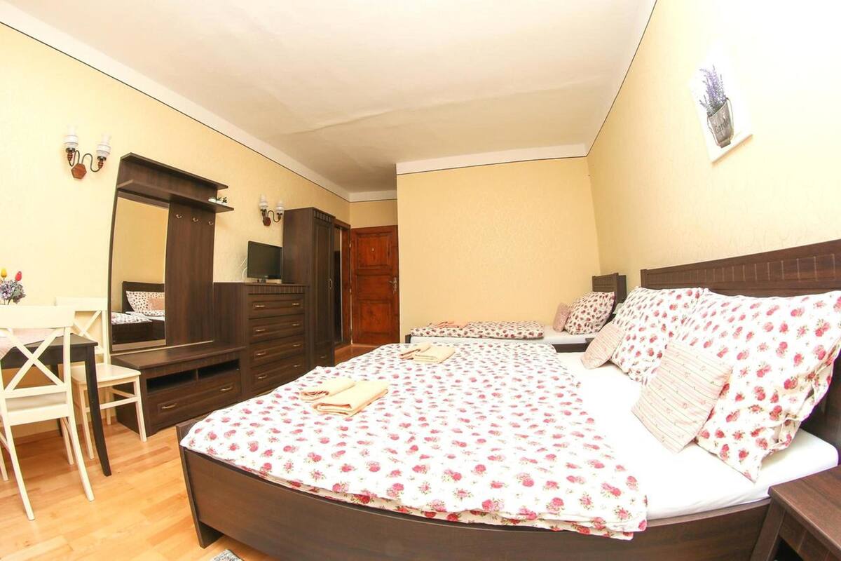 A bedroom with a bed, a desk, and a chair.