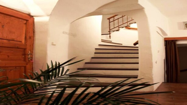 A staircase with a wooden handrail and a wooden door on the left. - Mini Hotel Abraka (Cesky Krumlov)