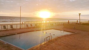 A swimming pool with a view of the ocean and sunset. - #102 First Floor, Direct Ocean Front, 2 King Beds, 1 Queen Murphy, Dog Free 20# (Daytona Beach)