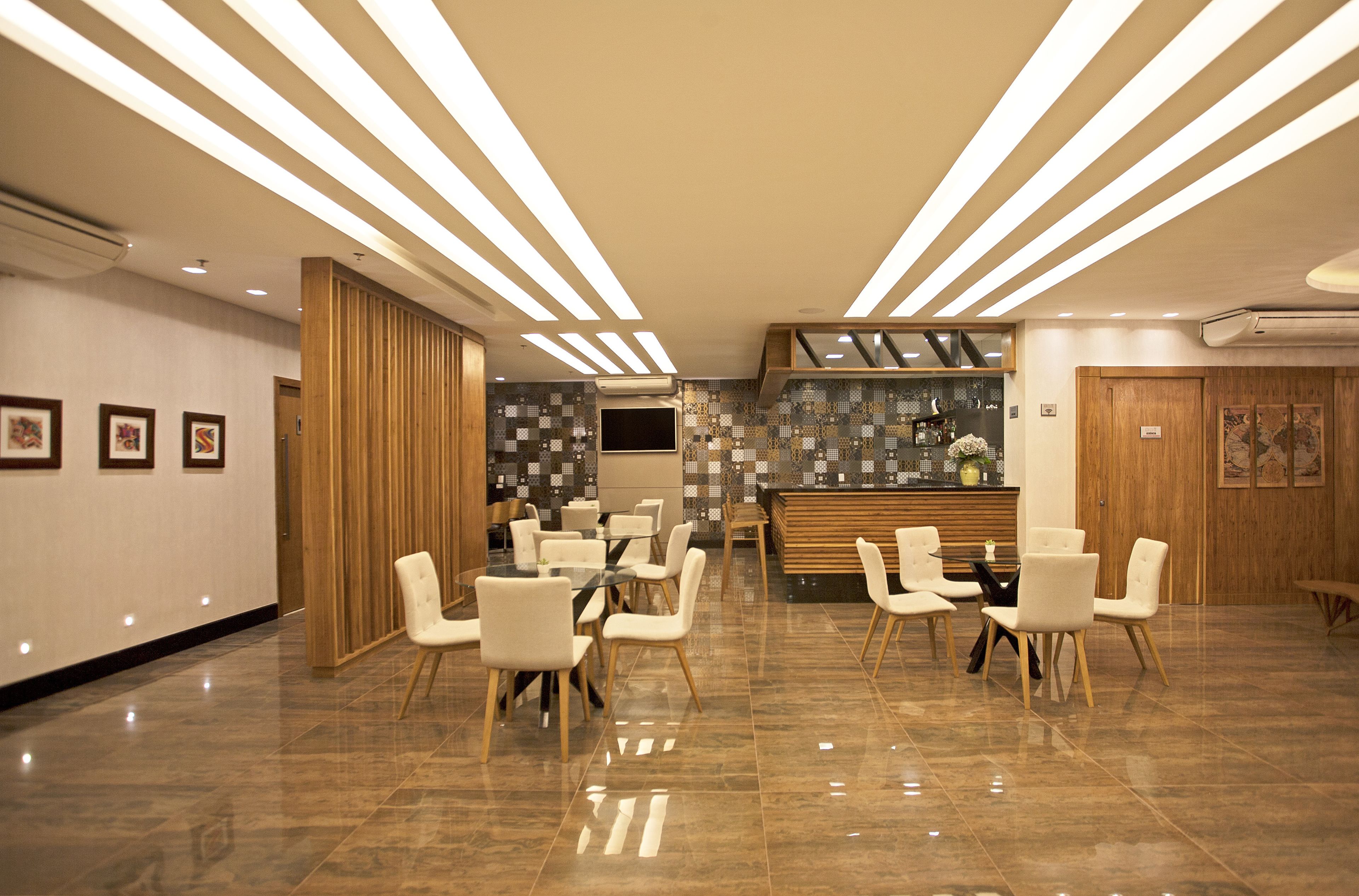 Un moderno vestíbulo de hotel con mostrador de recepción, zona de estar y una pared decorativa con diseño en mosaico.