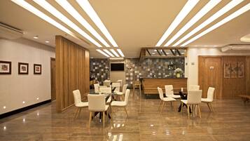 Un moderno vestíbulo de hotel con mostrador de recepción, zona de estar y una pared decorativa con diseño en mosaico.