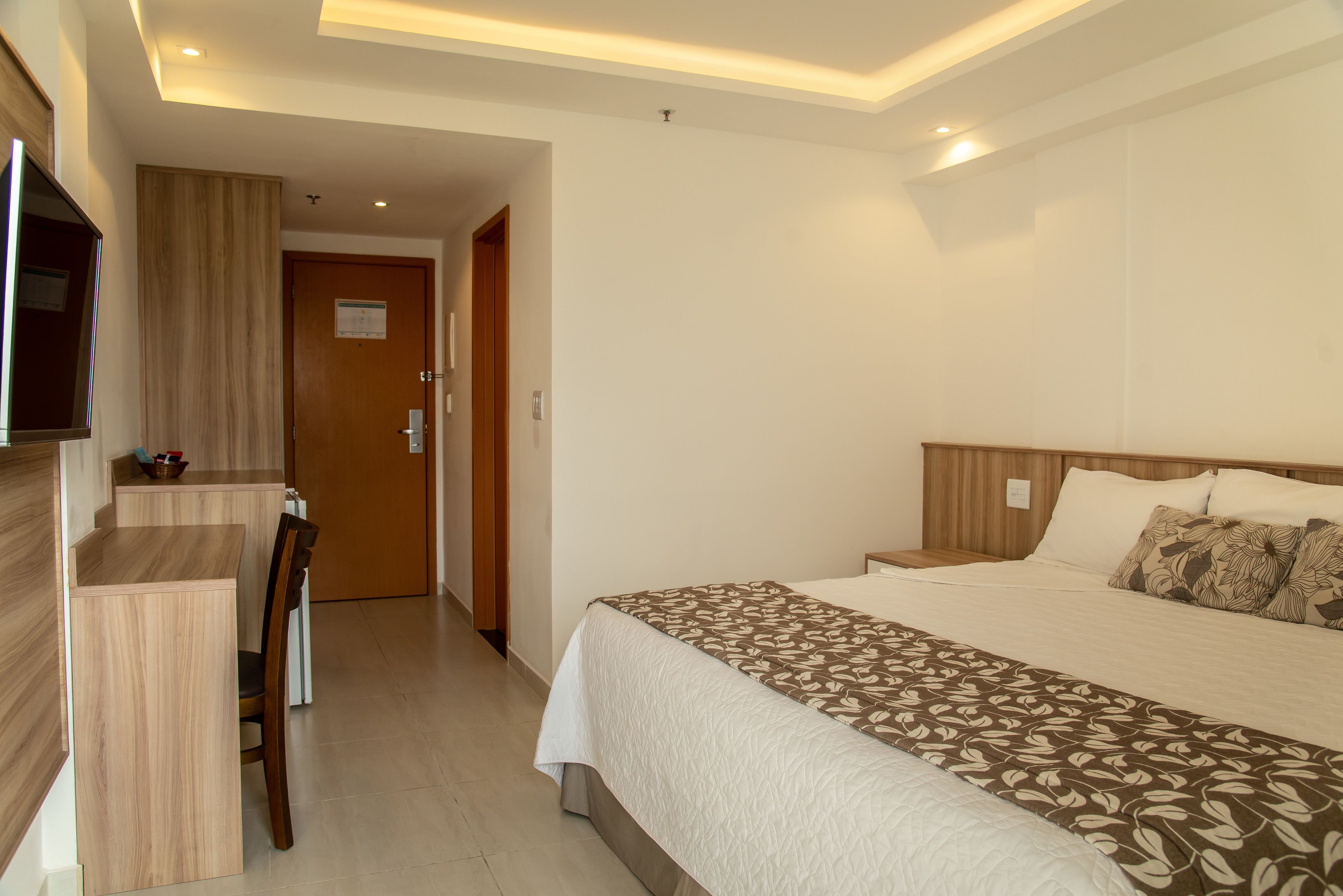 Una habitación de hotel con una cama, un escritorio y una silla.