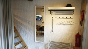 A room with a wooden ladder, a mirror, a drying rack, and a fire extinguisher. - Stenrosgården logi (Kivik)