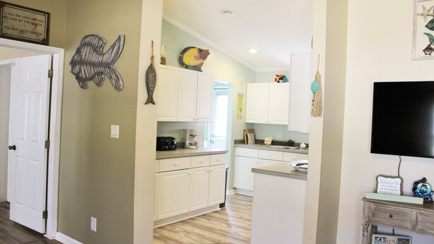 A kitchen with white cabinets, a coffee maker, and a refrigerator. - LITTLE SLICE OF PARADISE !!! ONLY 3 miles to The Beach!!🏖 (supply)