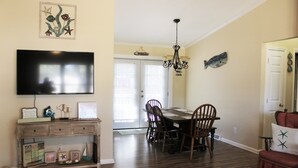 A dining area with a wooden table, chairs, and a chandelier. - LITTLE SLICE OF PARADISE !!! ONLY 3 miles to The Beach!!🏖 (supply)