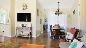 A living room with a TV, wooden furniture, and a chandelier. - LITTLE SLICE OF PARADISE !!! ONLY 3 miles to The Beach!!🏖 (supply)