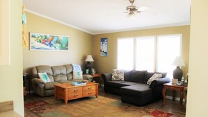 A living room with two sofas, a coffee table, and a rug. There are two lamps and a ceiling fan. - LITTLE SLICE OF PARADISE !!! ONLY 3 miles to The Beach!!🏖 (supply)