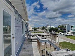 A residential building with a wooden deck and a view of a street with parked cars. - Hoff 1 | Walk to the Beach + Sound, Pet Friendly! (Topsail Beach)