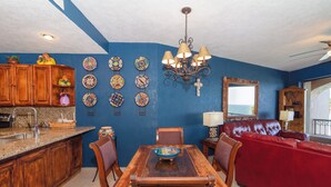 A dining area with a wooden table, chairs, and a red sofa.