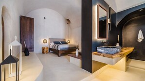 Een moderne slaapkamer met een bed, nachtkastje en een grote spiegel.