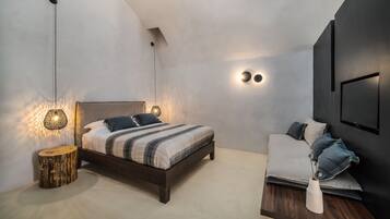 Un dormitorio moderno con cama, mesitas de noche e iluminación empotrada.