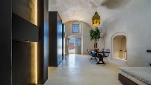 Een ruime kamer met een eethoek, een bed en een hanglamp.