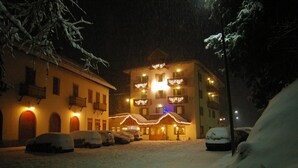 Un hôtel doté de nombreux balcons, dont le sol est recouvert de neige et dont les fenêtres sont illuminées.