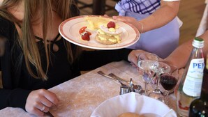 Un espace repas avec des tables, des chaises et une bouteille de vin posée sur la table.