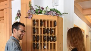 Un homme et une femme interagissent avec une vitrine en bois contenant des clés et des jeux de société.