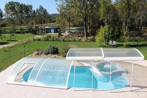 A swimming pool with a glass enclosure and a hot tub. - Chambres d'hotes Gite du Puy de l'Étang (Laruscade)