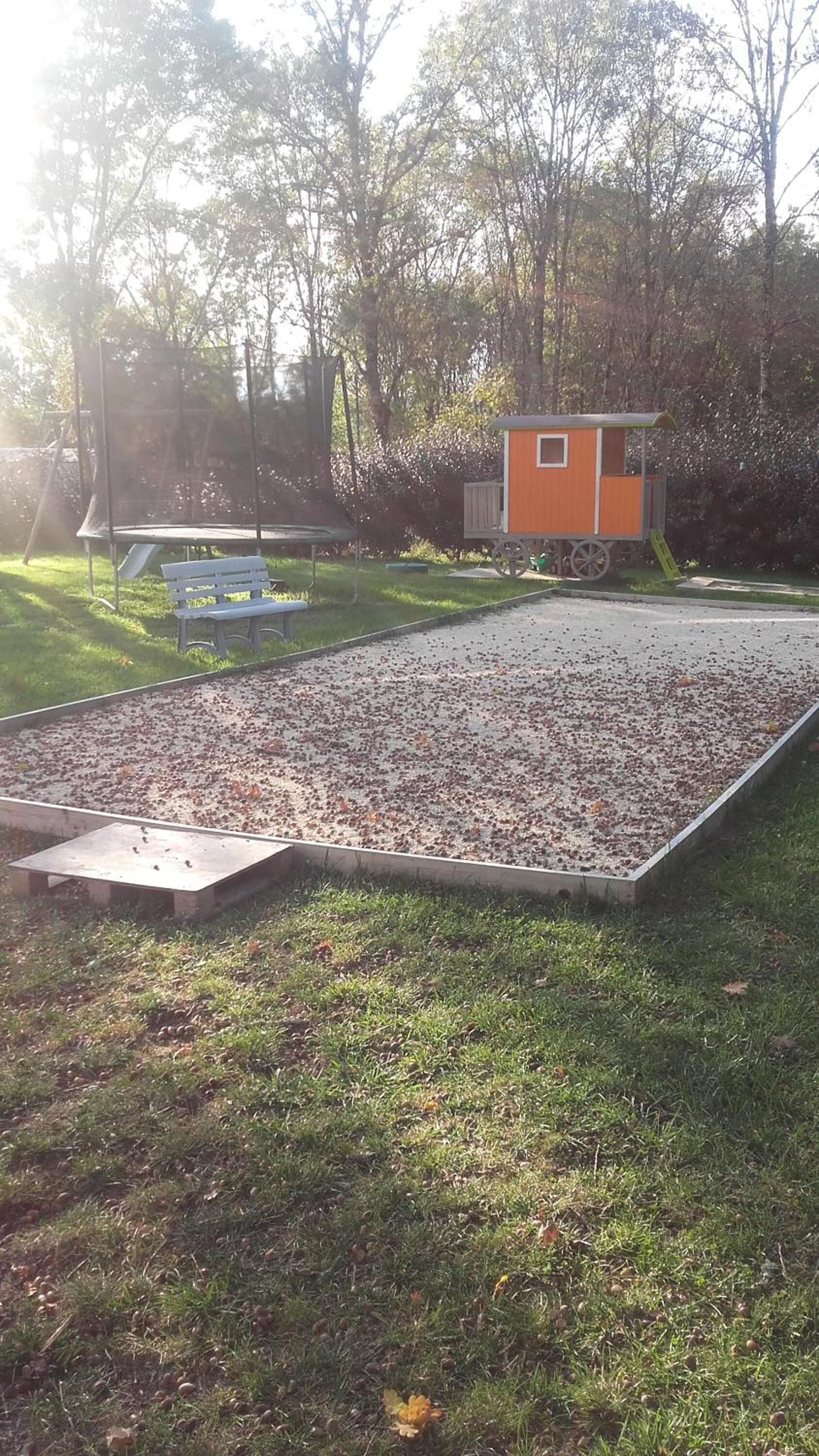 A playground with a slide and a small orange shed.