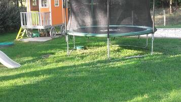 A trampoline with a safety net in a grassy area.