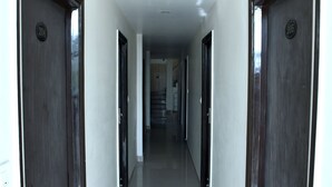 A hallway with dark wooden doors, each marked with a number. - Hotel Metro View (Jaipur)