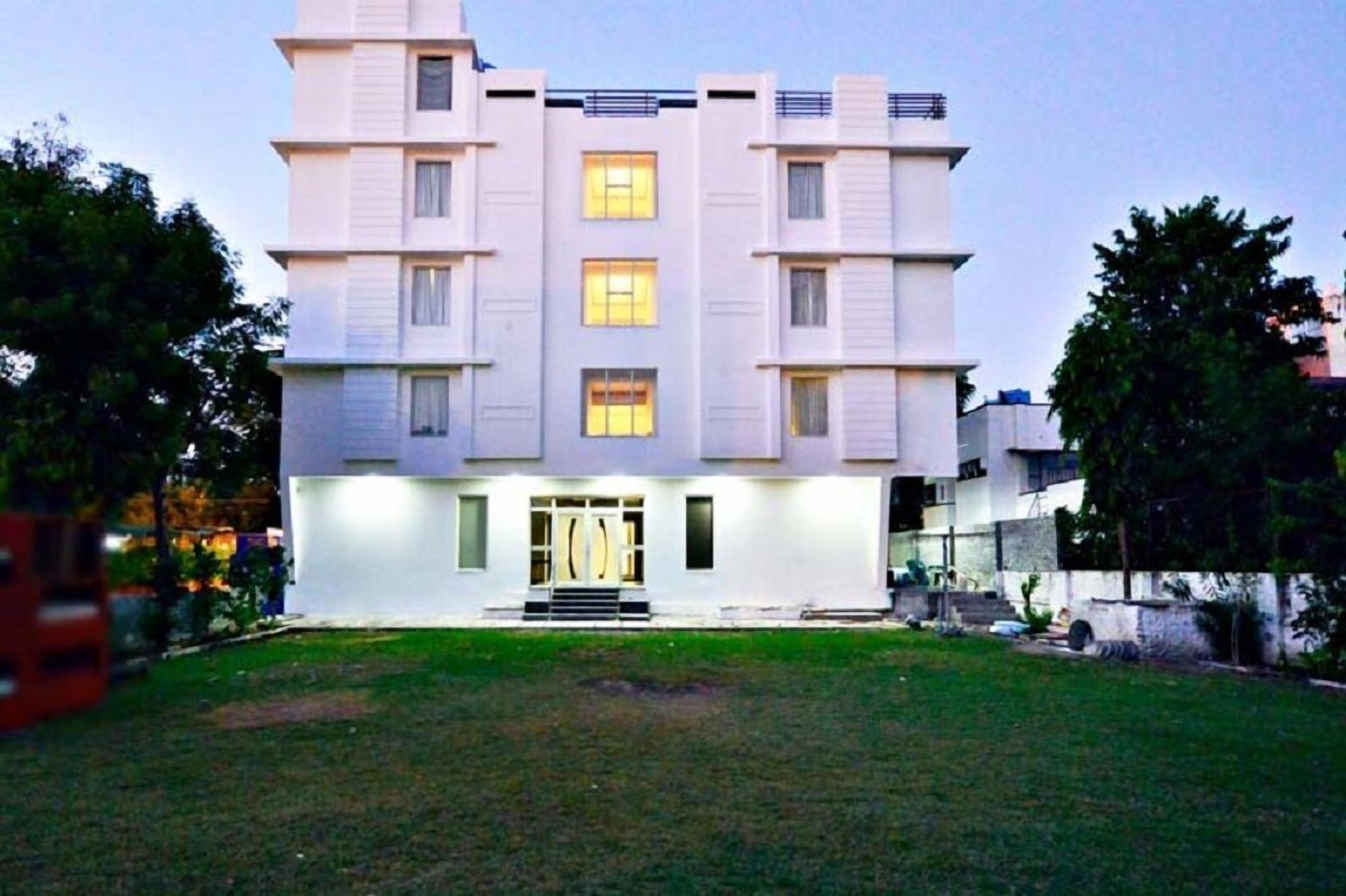 Un moderno edificio de varios pisos con techo plano, ventanas grandes y una entrada central con escalones.