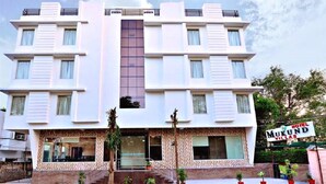 Un hotel moderno con fachada simétrica, ventanas amplias y una entrada central con escalones.