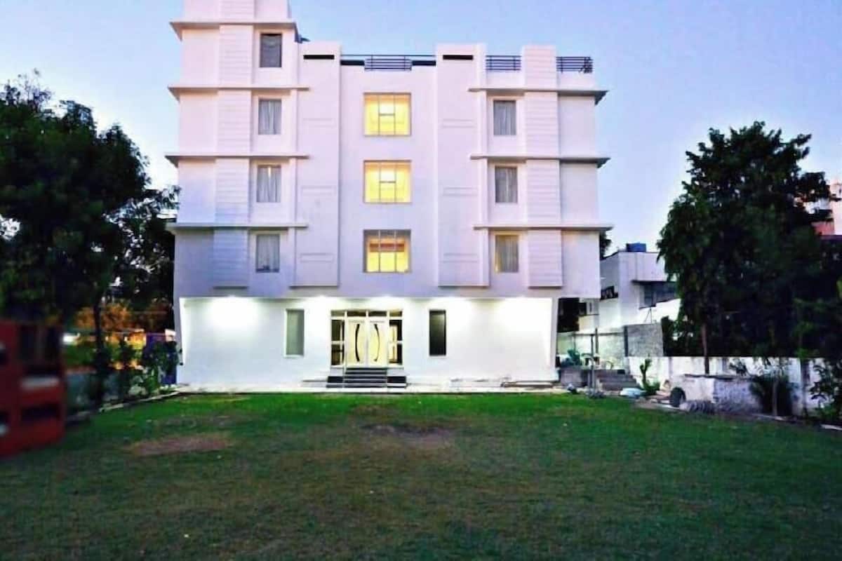 Un edificio de varios pisos con fachada simétrica, ventanas amplias y una entrada central con escalones.