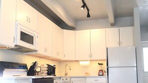 A modern kitchen with white cabinets, a microwave, stove, and a refrigerator. - 3-bedroom condo in downtown Frisco - Near Lake Dillon.  (Frisco)