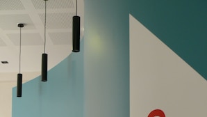 Un couloir avec un mur de couleur turquoise et une enseigne blanche sur laquelle on peut lire « Resto ».