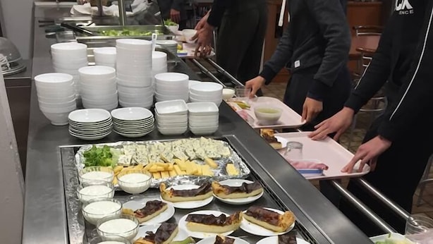 Un buffet proposant une variété de plats et un panier de fruits.