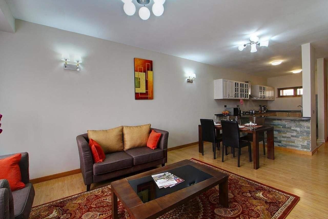 Sala de estar com sofá, mesa de centro e área de refeições com cadeiras e mesa.