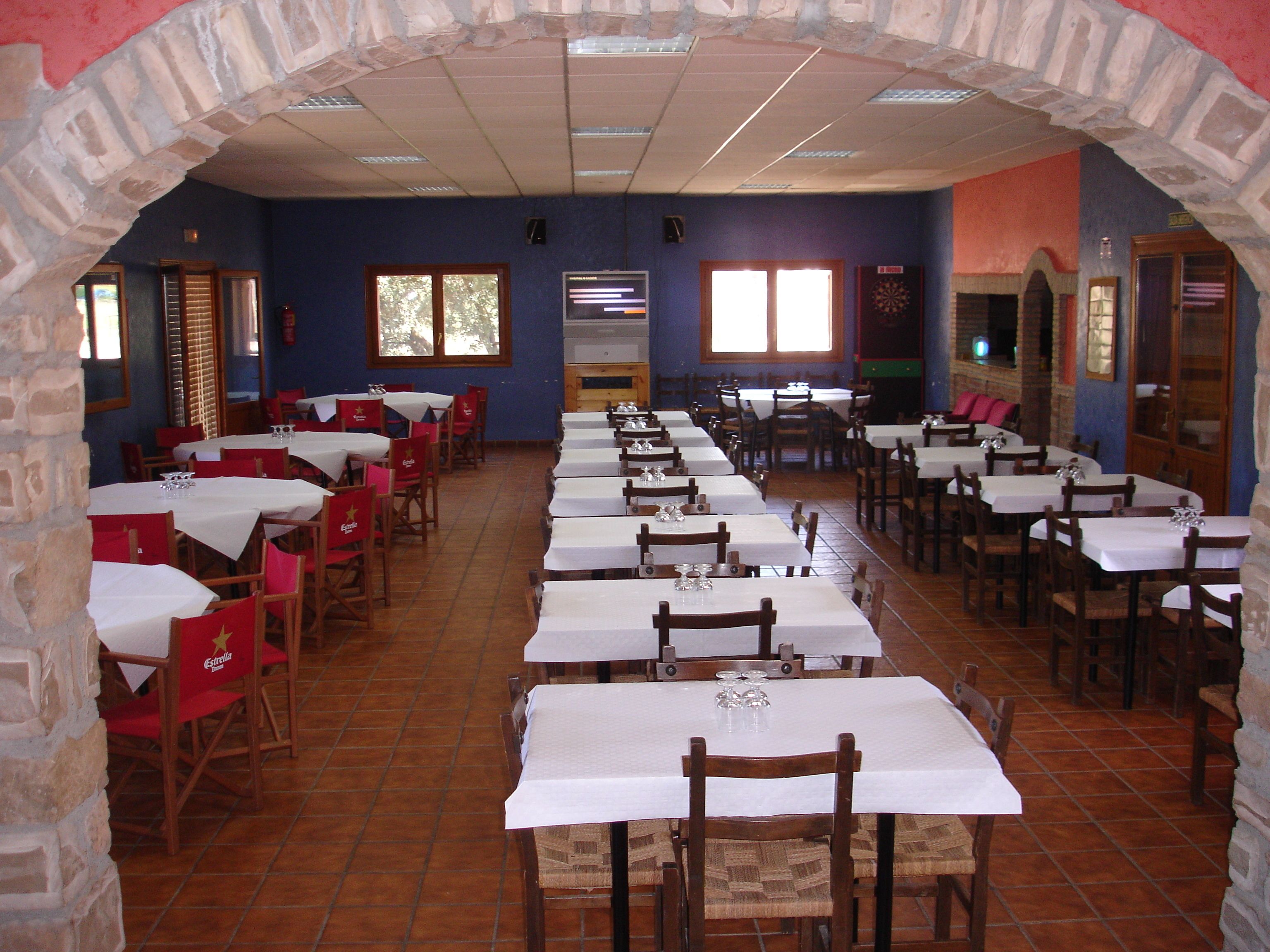 A restaurant with multiple tables and chairs, arranged in rows.
