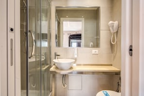 A modern bathroom with a glass-enclosed shower, a white sink, and a built-in mirror. - Aurelia Vatican Suites (Rome)