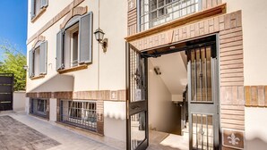 A building with a large open door, a balcony, and a tiled ground. - Aurelia Vatican Suites (Rome)