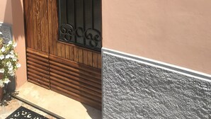 Una puerta de madera con una rejilla metálica decorativa, un cartel con el número 8 y una placa que dice 'L'Opera Pub & Bar'.