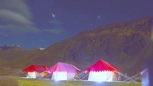 A row of tents with a mountainous backdrop. - Himalayan Routes Camp (Lahul)